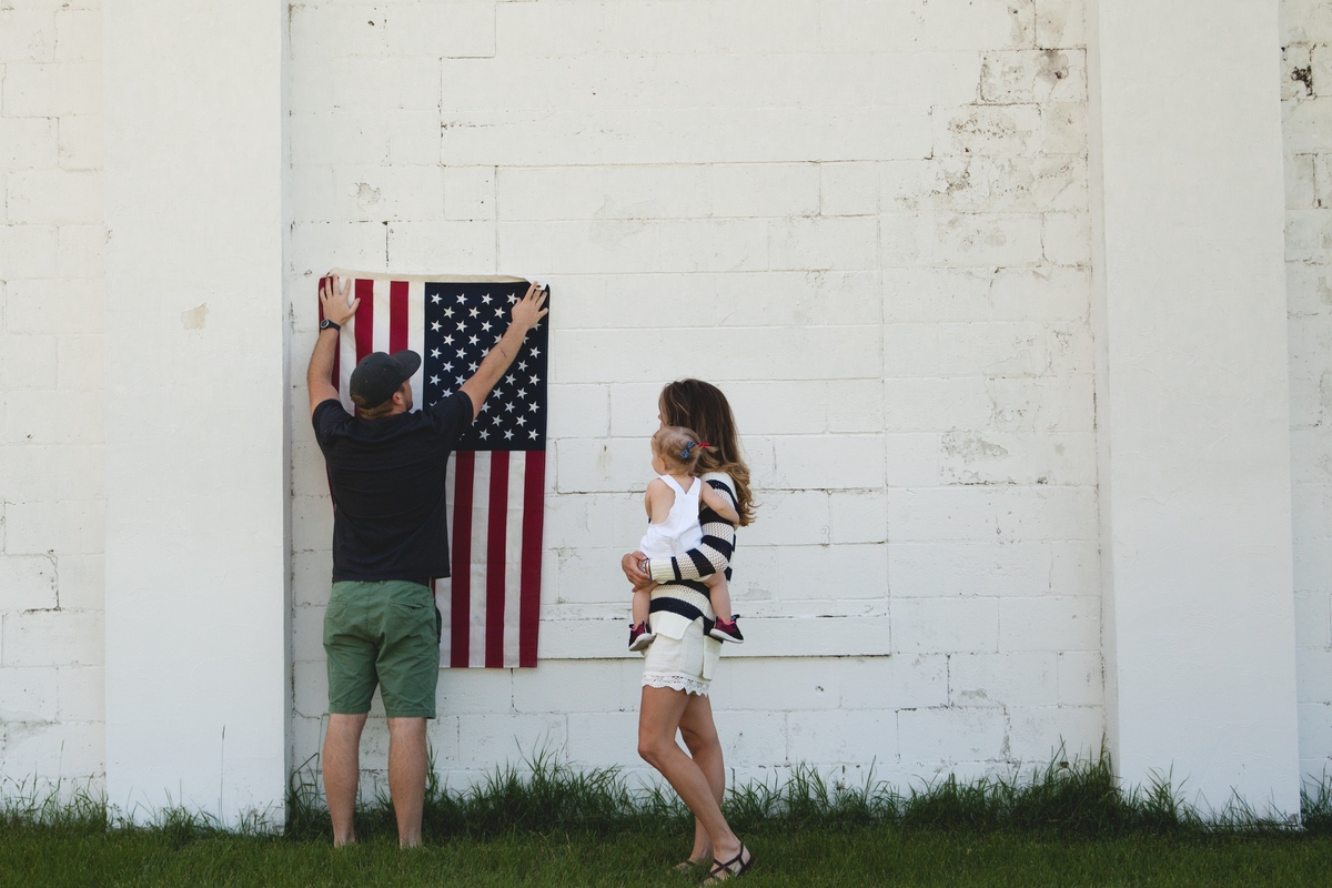 young millennial parents with flag