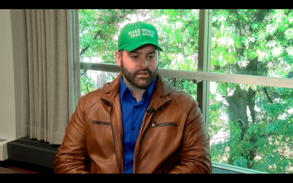 gab ceo andrew torba wears a green make speech free again hat 